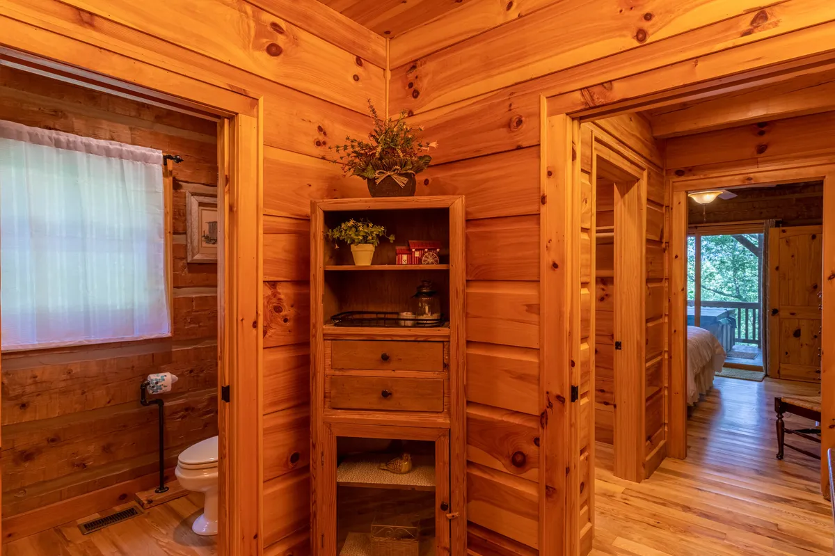 A warm, rustic nook with wooden walls, a decorative cabinet, and doorways leading to other rooms, suggesting a spacious floor plan. The ambiance encourages morning coffee or evening relaxation, with natural light hinting at the retreat’s mountain setting.
