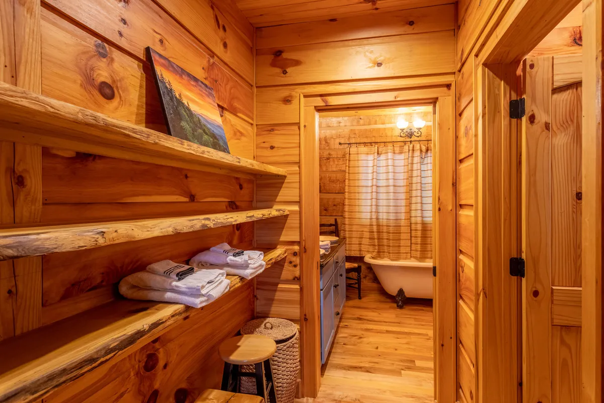 A charming bathroom scene featuring a classic clawfoot bathtub surrounded by wooden shelves and tasteful artwork. The setting invites guests to unwind in a luxurious bath, enhancing the romance and relaxation promised in the section description.